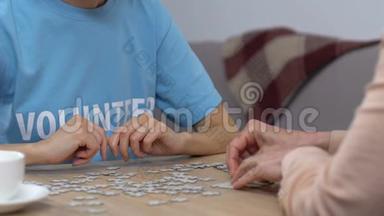 <strong>青年志愿者</strong>和老年妇女在养老院做拼图游戏，休闲活动